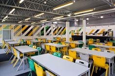Modern institutional cafeteria with bright yellow chairs and white tables in a spacious dining hall